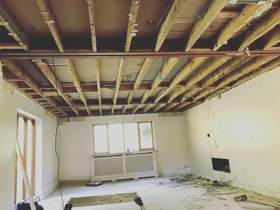 An unfinished room with a radiator and window.
