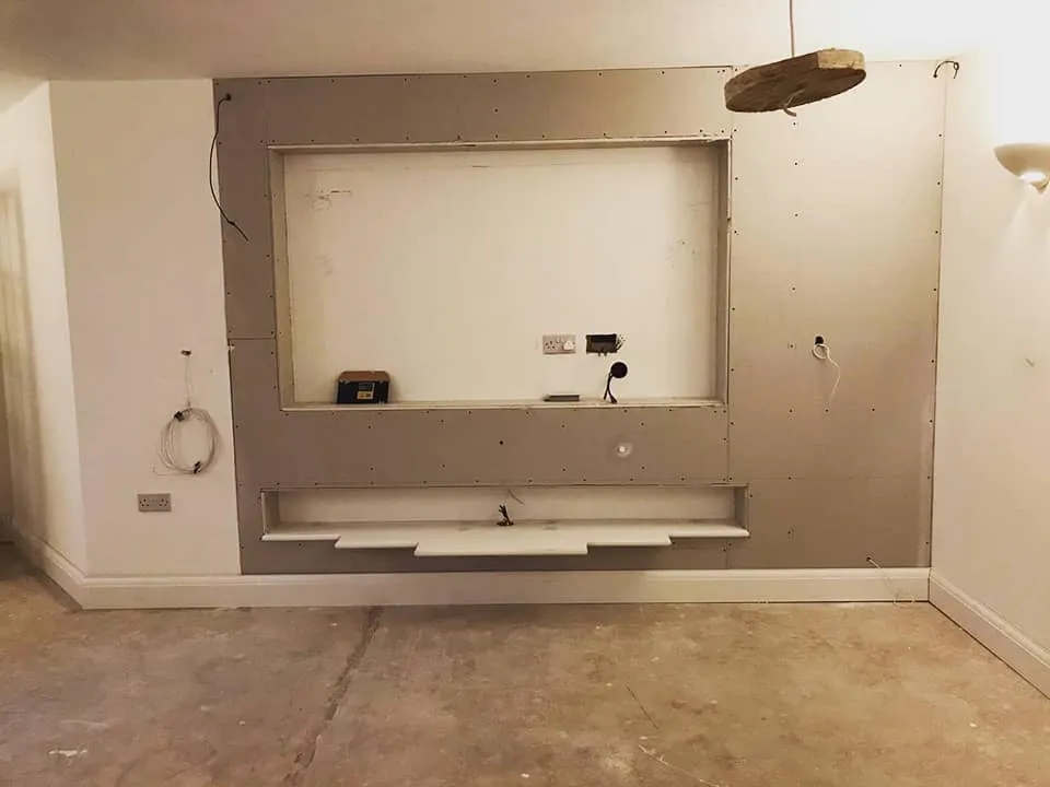 An empty room with a mirror and a light fixture.