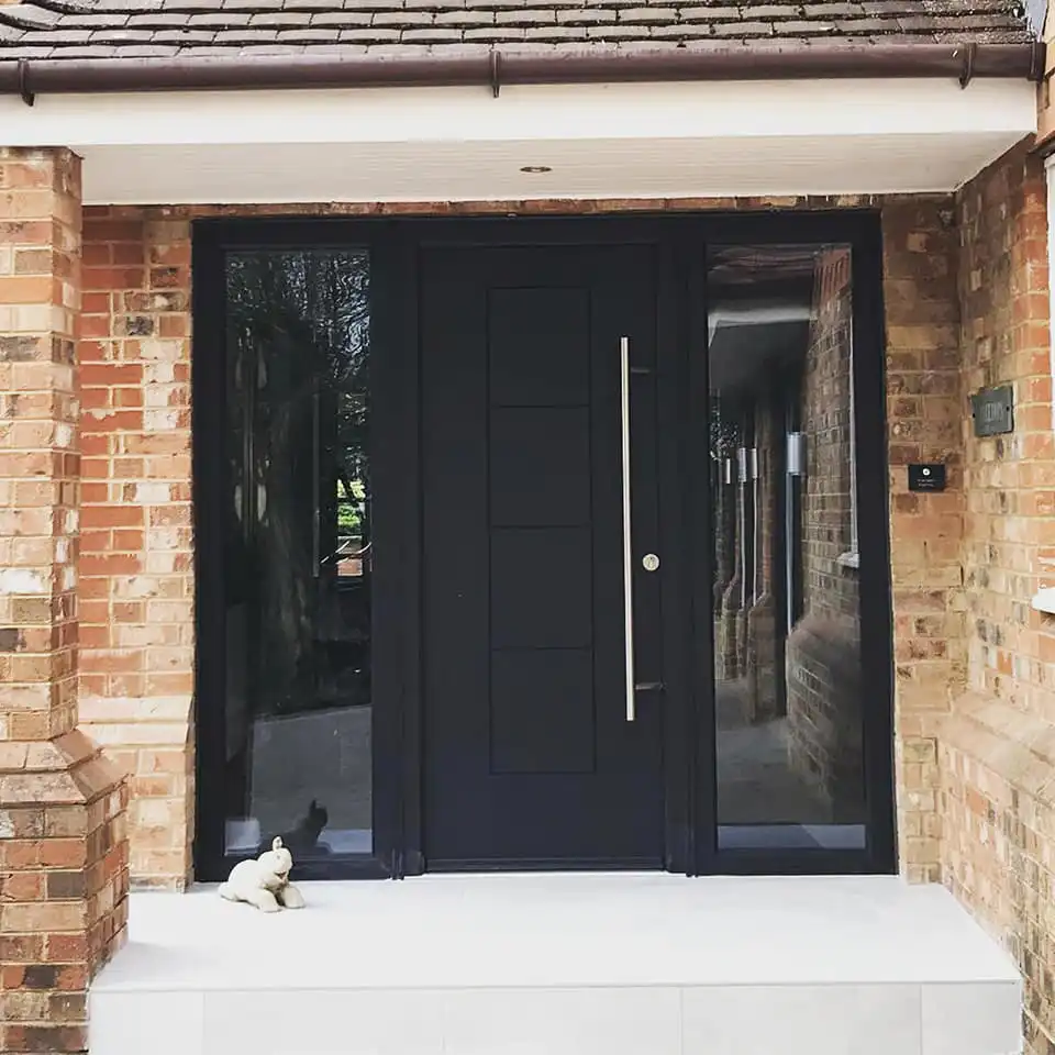 A dog sitting on a step in front of a door.